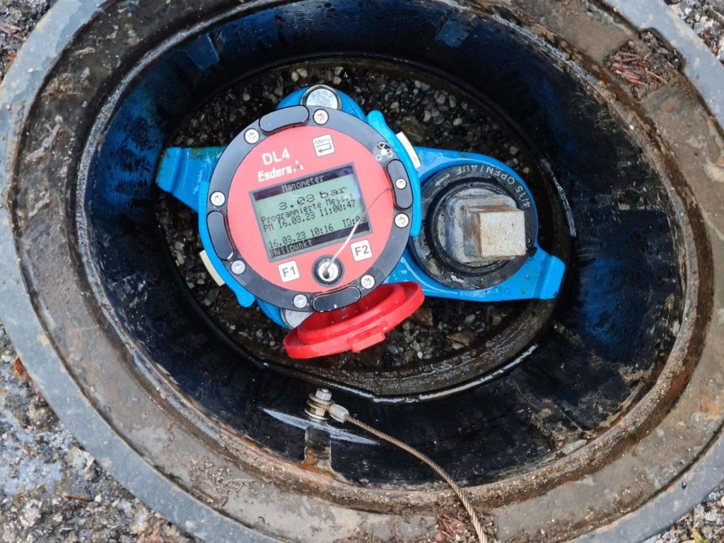 Ein Zähler in einem Loch mit rotem und blauem Deckel.